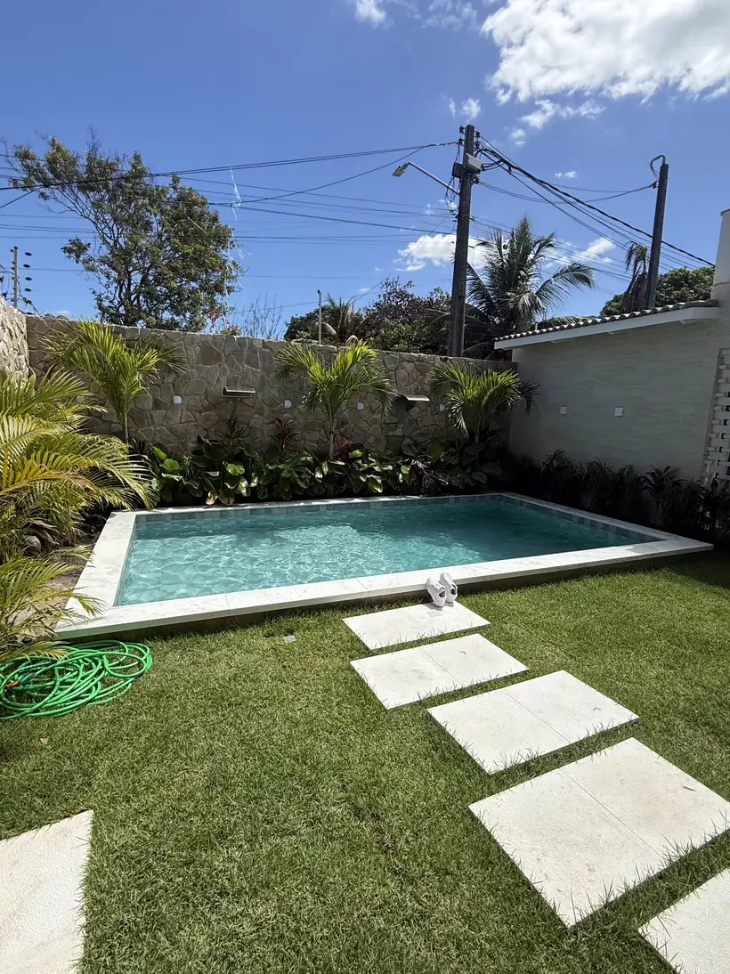 Caminho de placas no gramado até a piscina