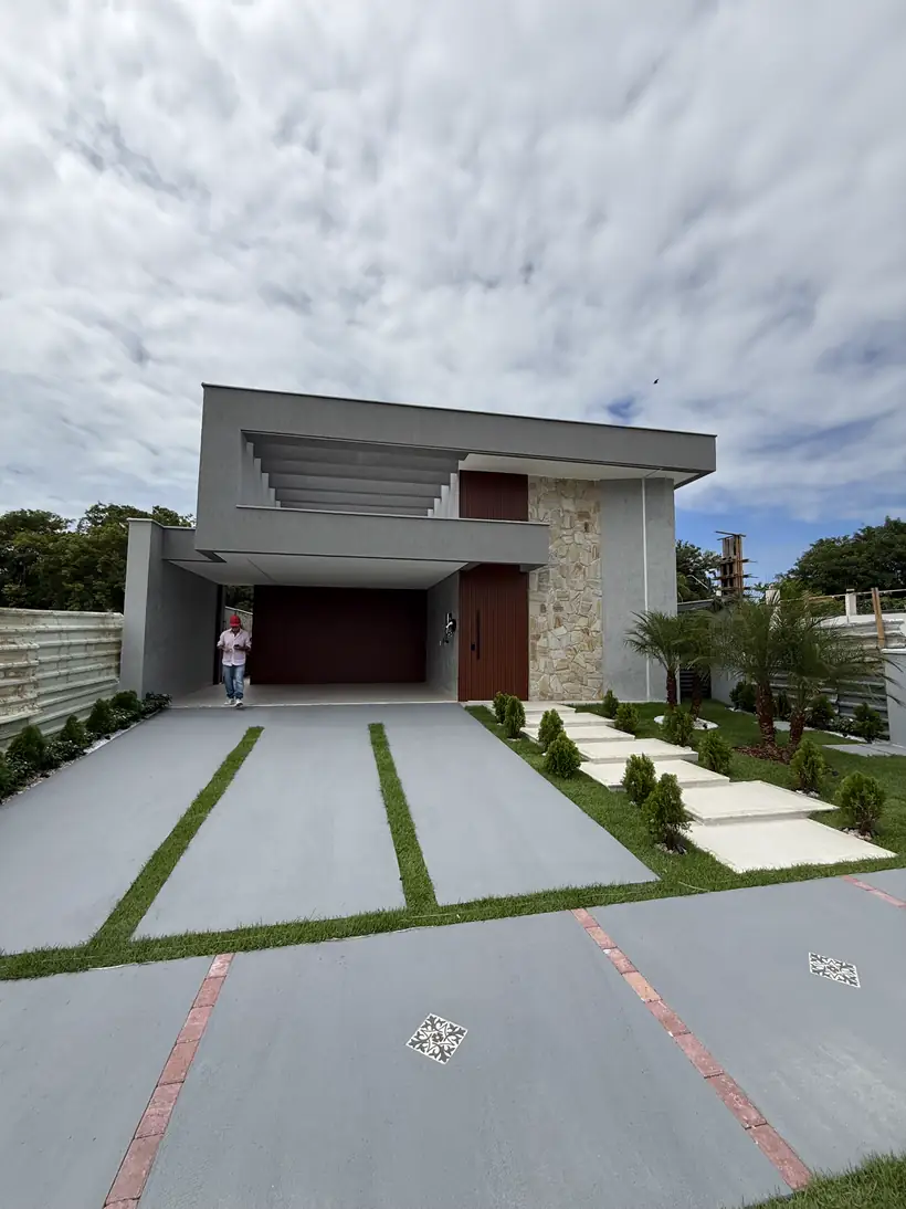 Fachada com pedra natural, brises e porta de madeira